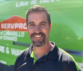 Portrait of Jason, male employee in front of green truck