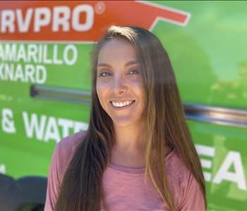 Portrait of Brittani, female employee in front of green truck